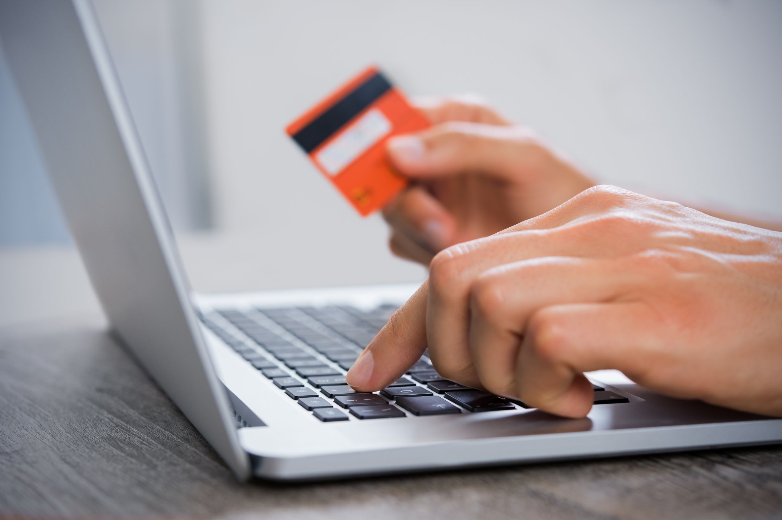 Person using a laptop to make a payment with a credit card.