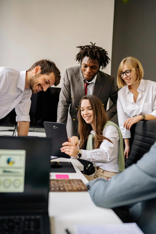 A group of coworkers watching something on a tablet