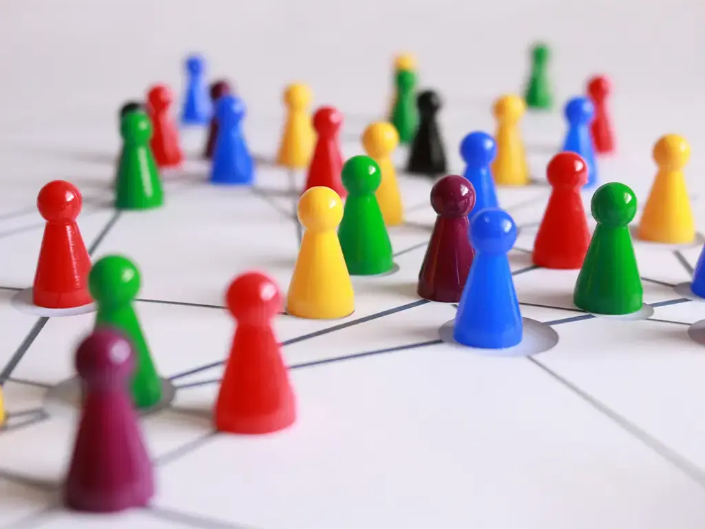 Colorful game pieces connected by lines representing a network or system collaboration.