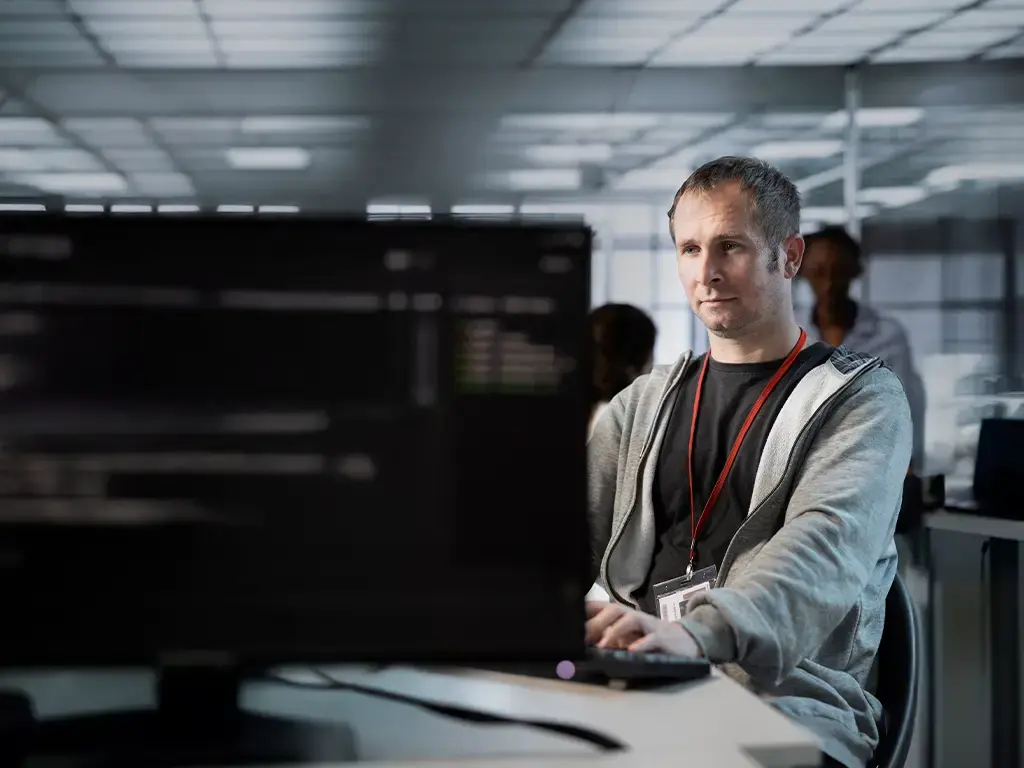 Engineer working at dual monitors in modern office, supporting media knowledge discovery with AI tools.