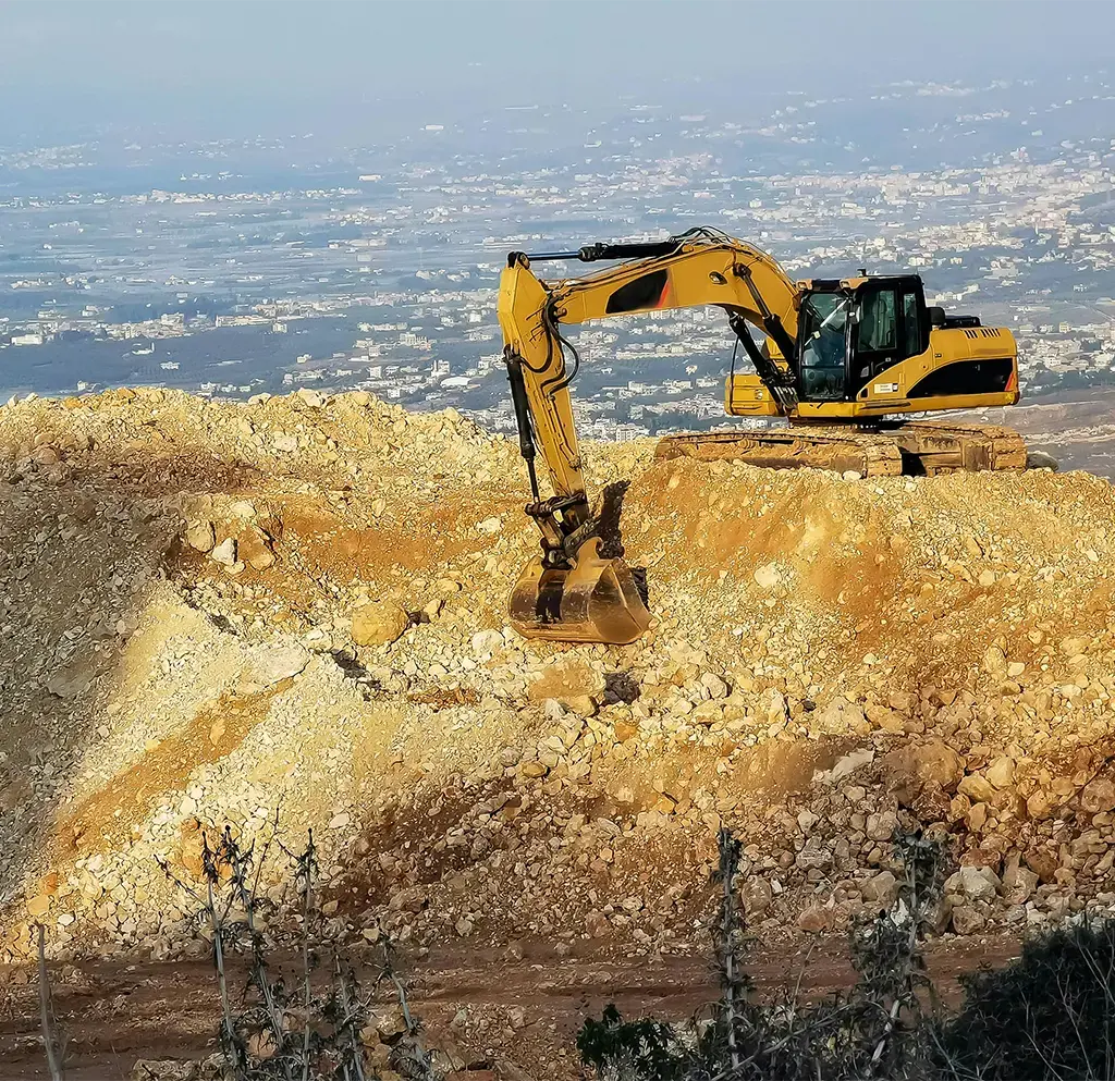 digging vehicle on top of rubble mound