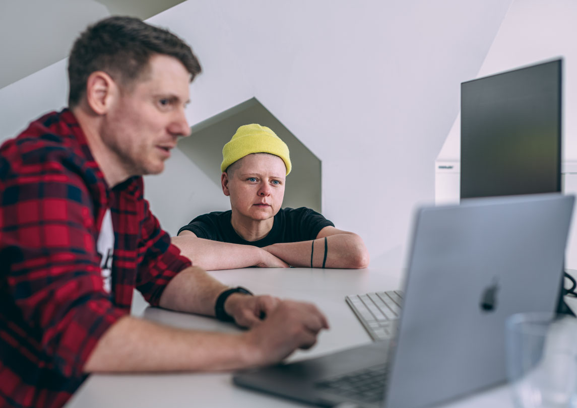 two people looking at a laptop