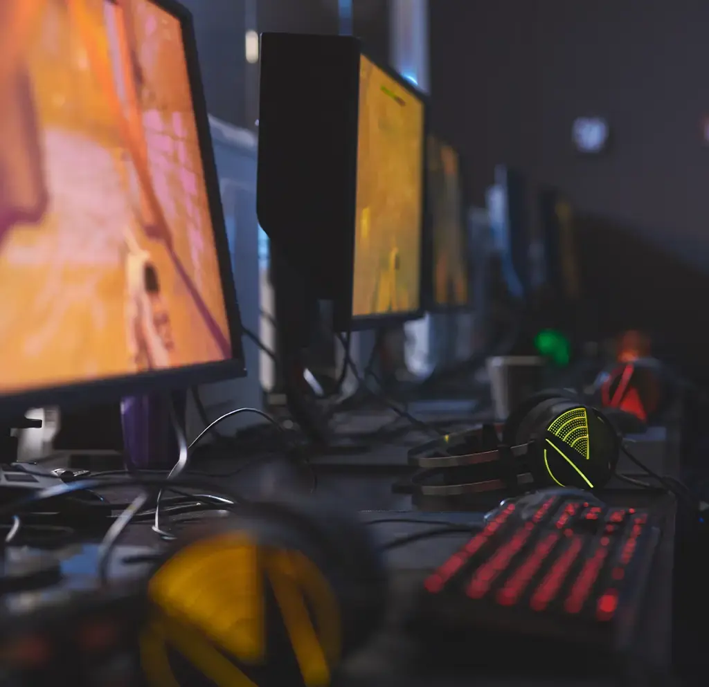 Row of gaming monitors and headsets in a development or testing studio setup.