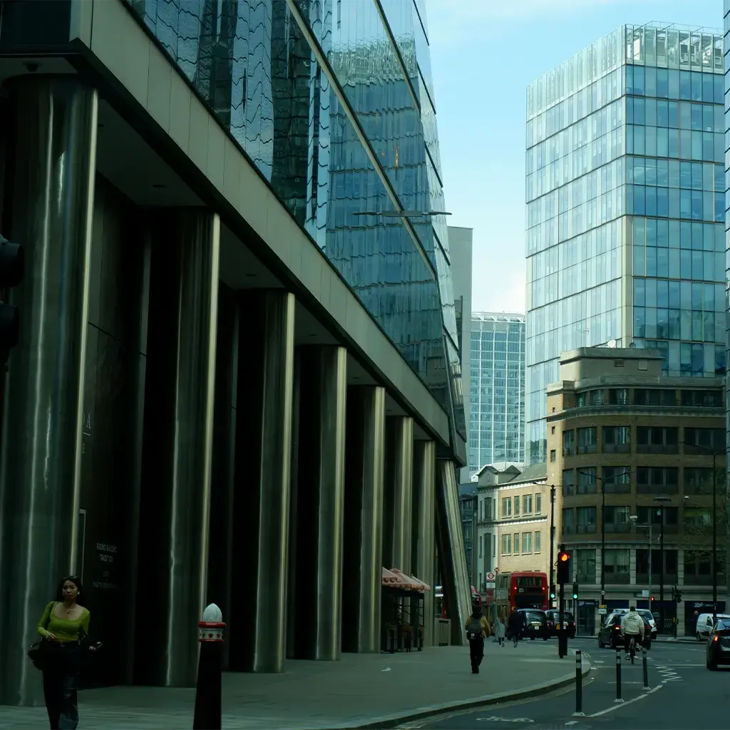 Modern city street with glass office buildings, traffic, and pedestrians in a financial district.