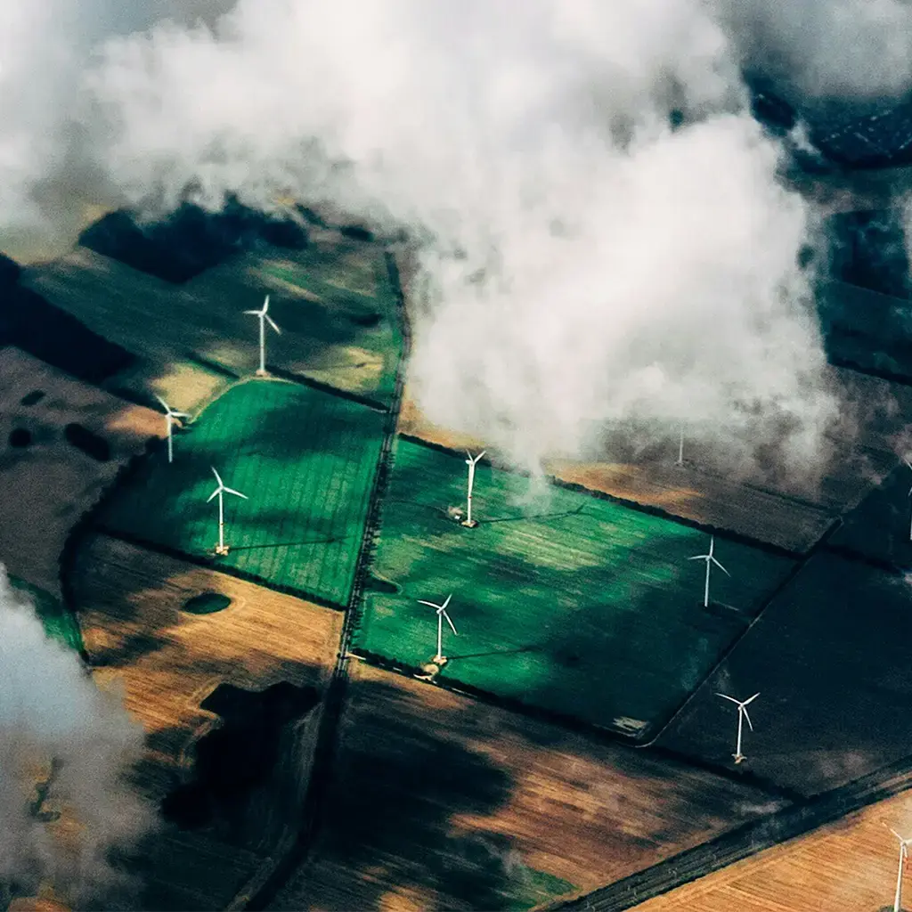 green and brown fields with green wind energy generation
