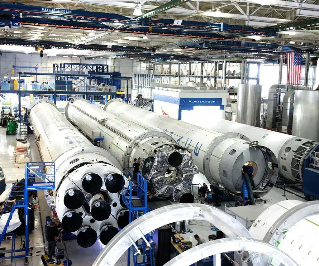 Rocket components being assembled in a high-tech manufacturing facility, showcasing aerospace innovation.