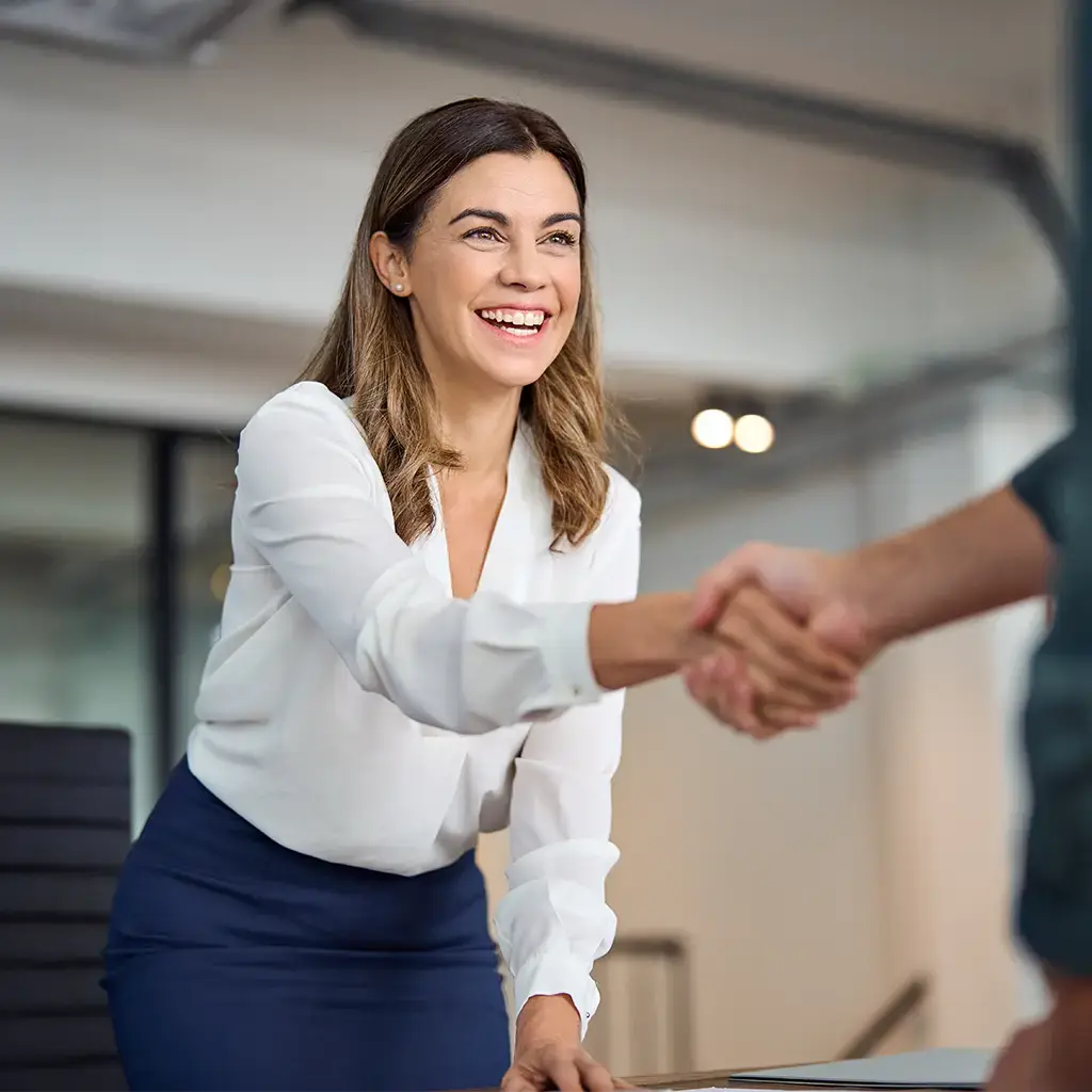 Professional handshake during a business meeting in a modern office setting.
