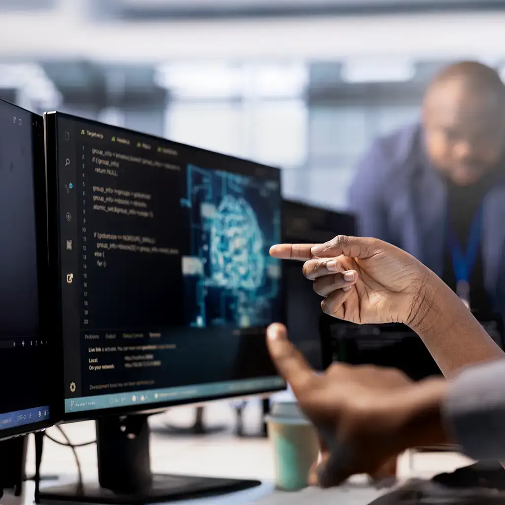 Team reviewing AI model code and data trends to drive innovation in financial services.