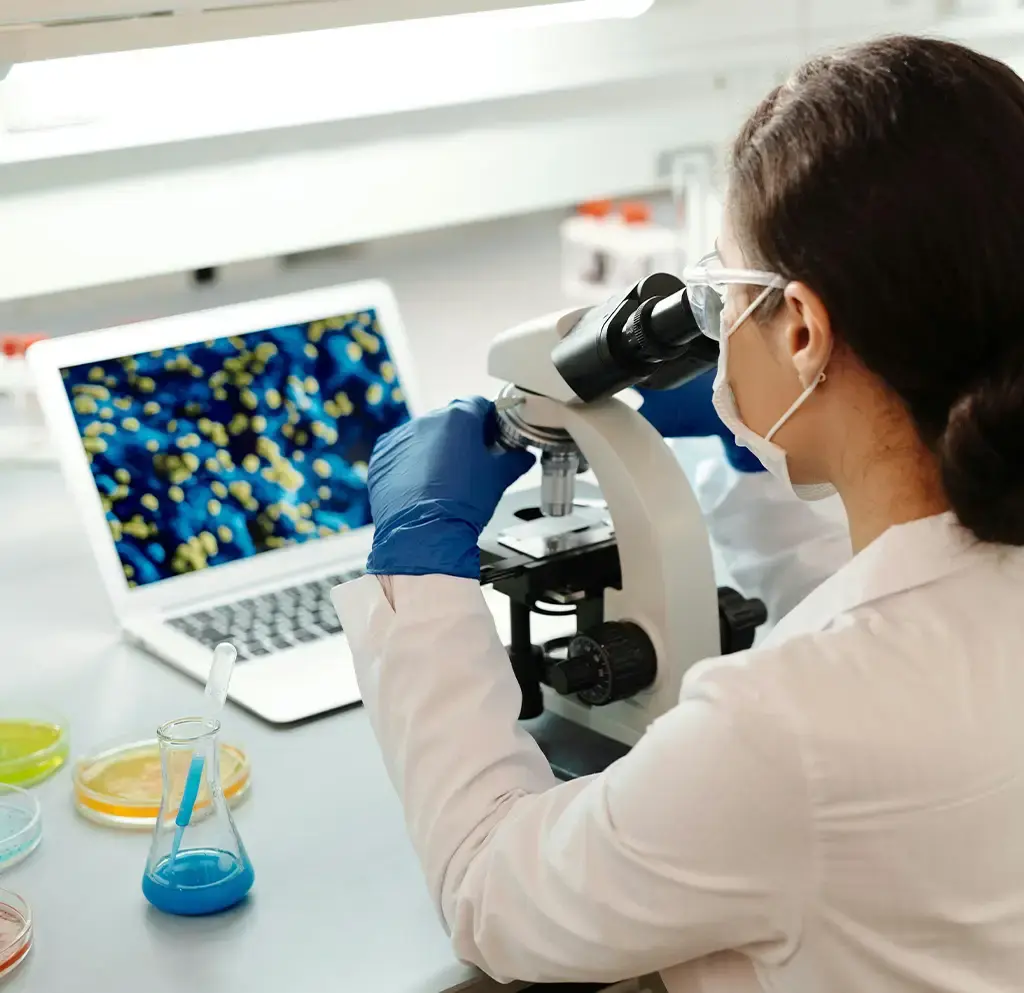 Scientist analyzing cell images on dual monitors in a high-tech laboratory