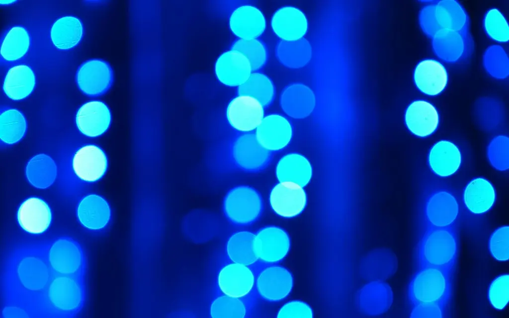 Abstract blue light dots forming vertical patterns, representing digital data flow and network connectivity