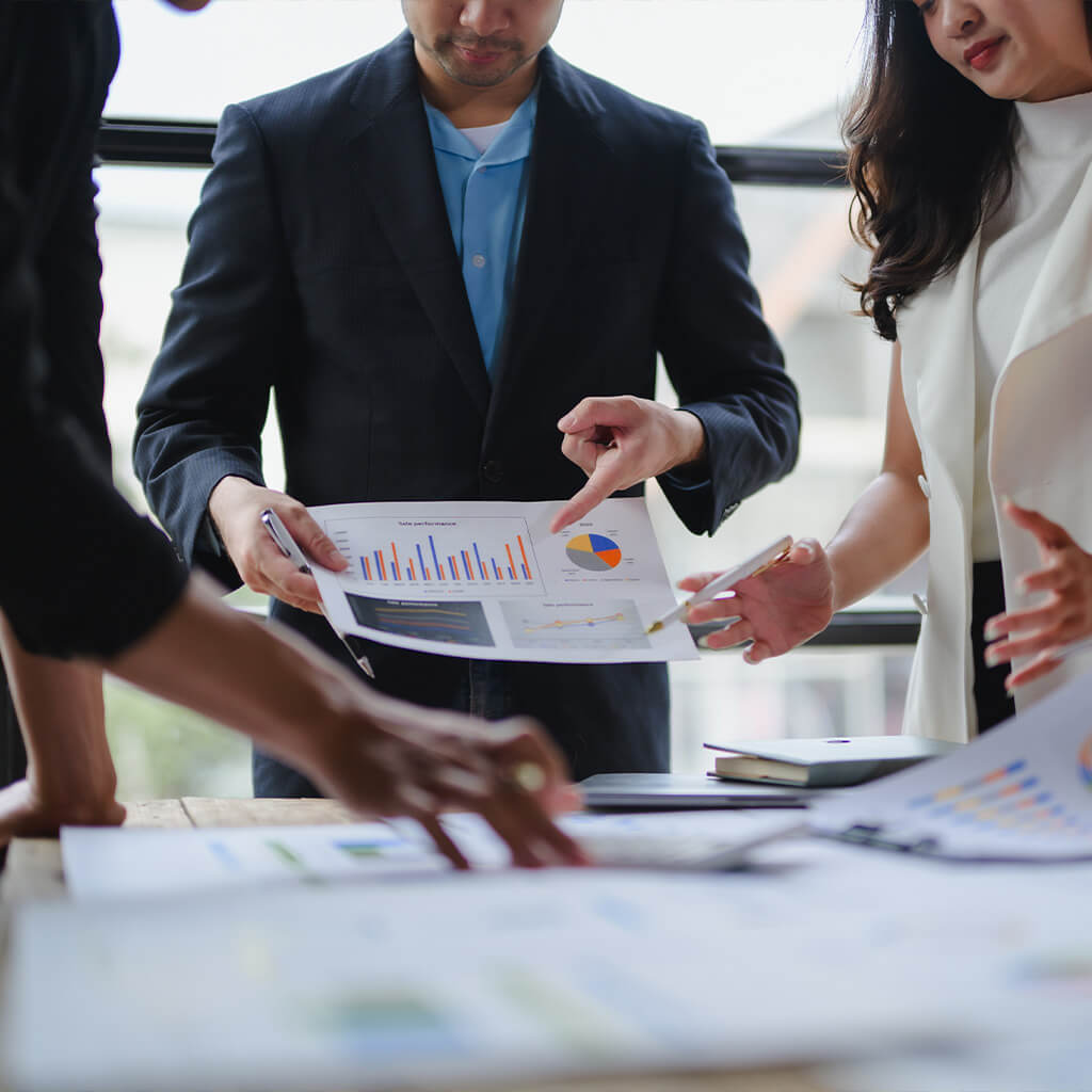 Team collaborating on business charts and data analysis at a modern workspace.