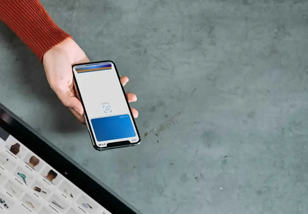 Customer using mobile wallet for payment at a digital point-of-sale terminal in a retail store.