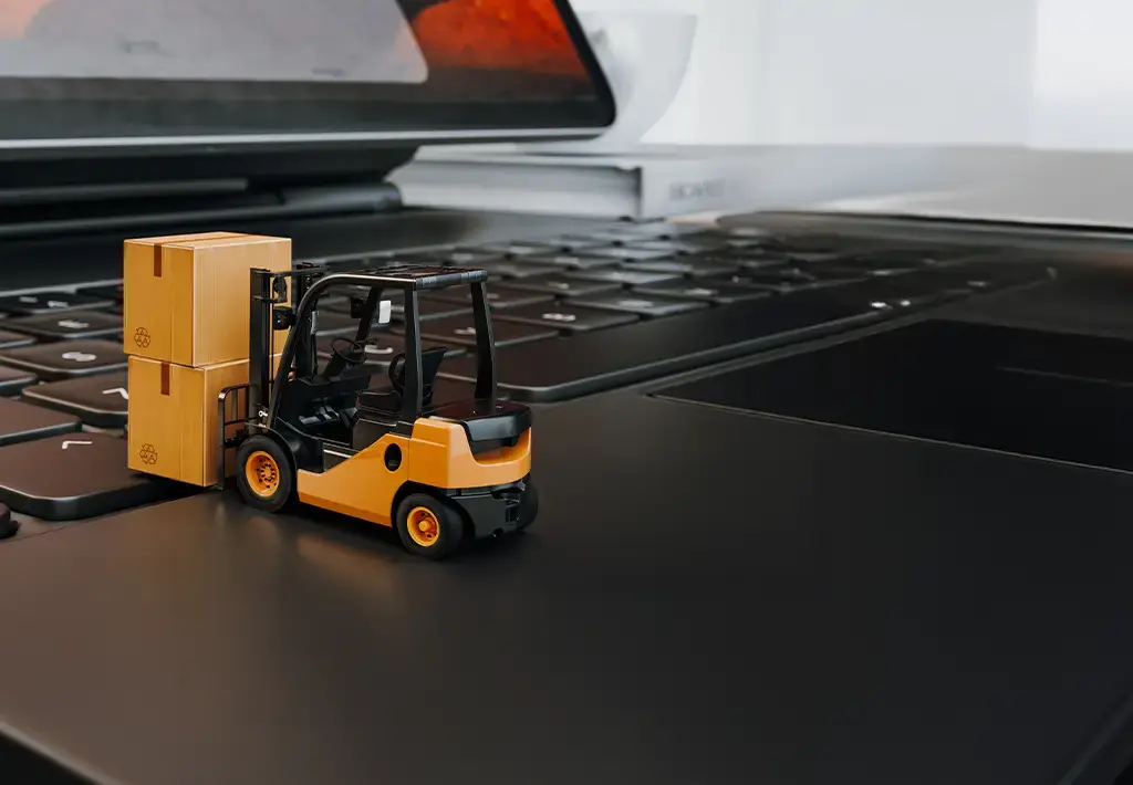Forklift moving boxes on laptop keyboard, illustrating smart logistics and supply chain digitization.