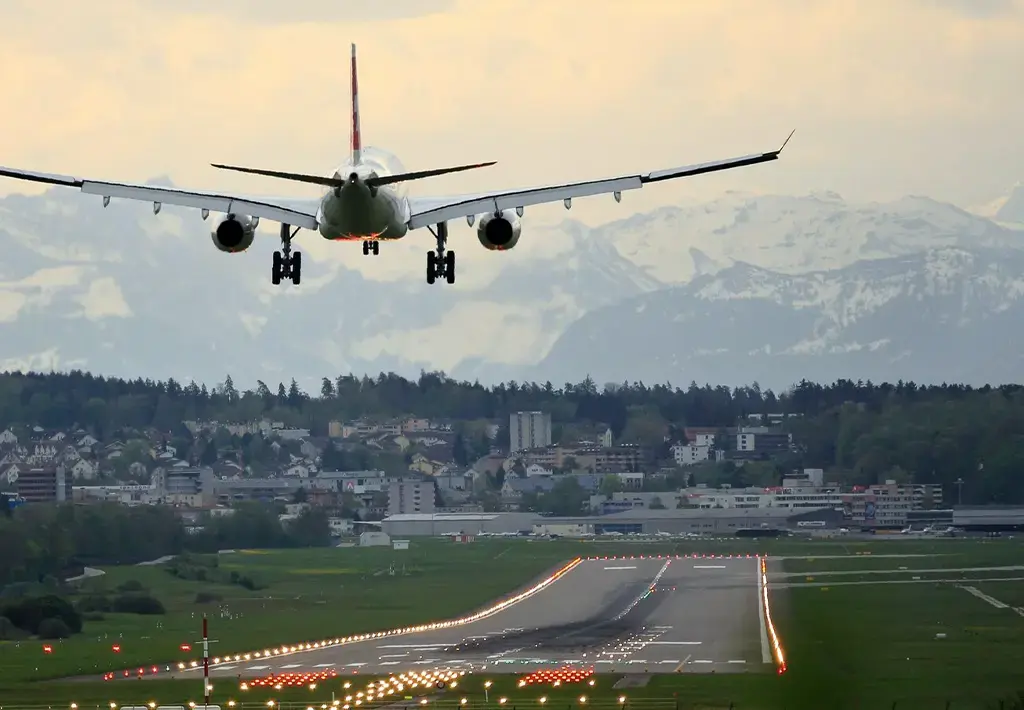 Airplane approaching runway with mountains in background, signaling global connectivity and logistics.