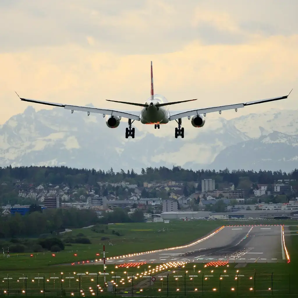 Airplane approaching runway with mountains in background, signaling global connectivity and logistics.