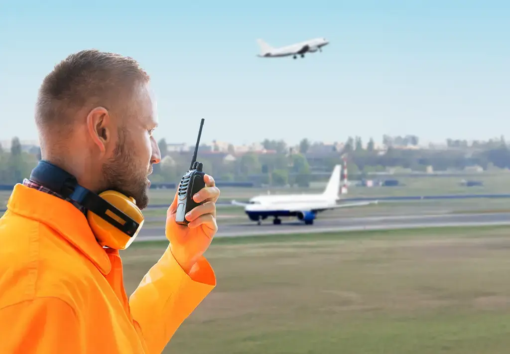 round crew member using radio at busy airport, highlighting need for digitalized operations.