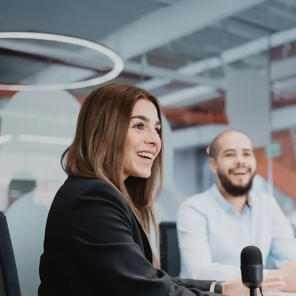 Professionals engaged in a discussion around a conference table with a microphone in focus.