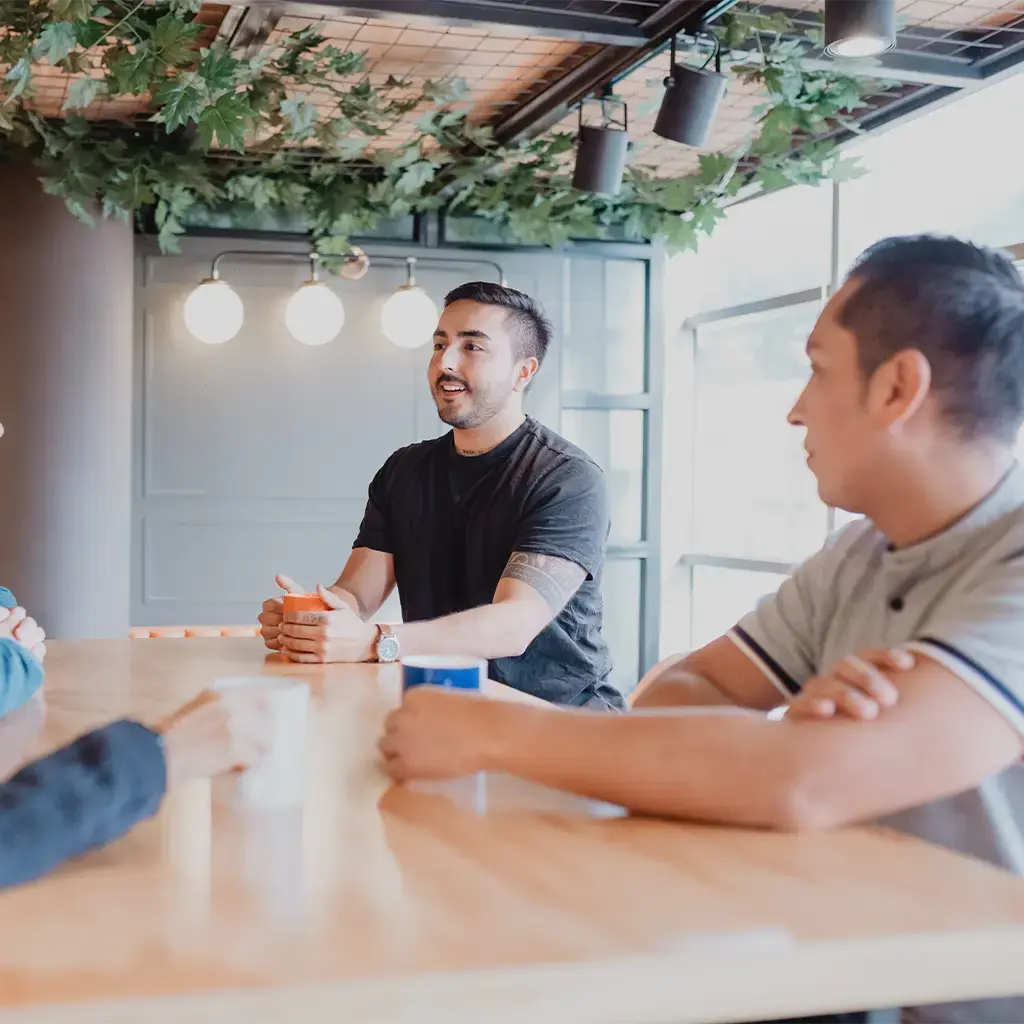 Team discussion around a meeting table in a modern office collaboration space