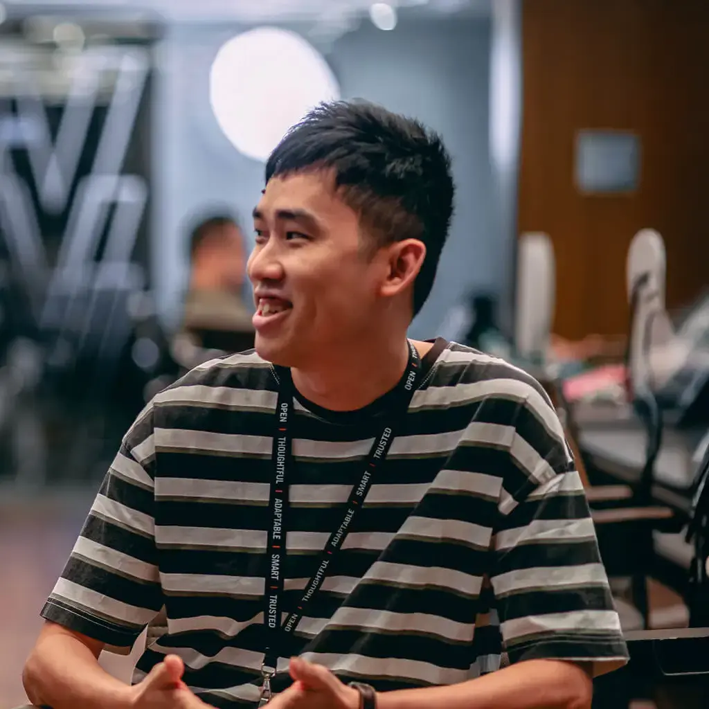Two colleagues having a casual discussion in a modern office setting in Vietnam.