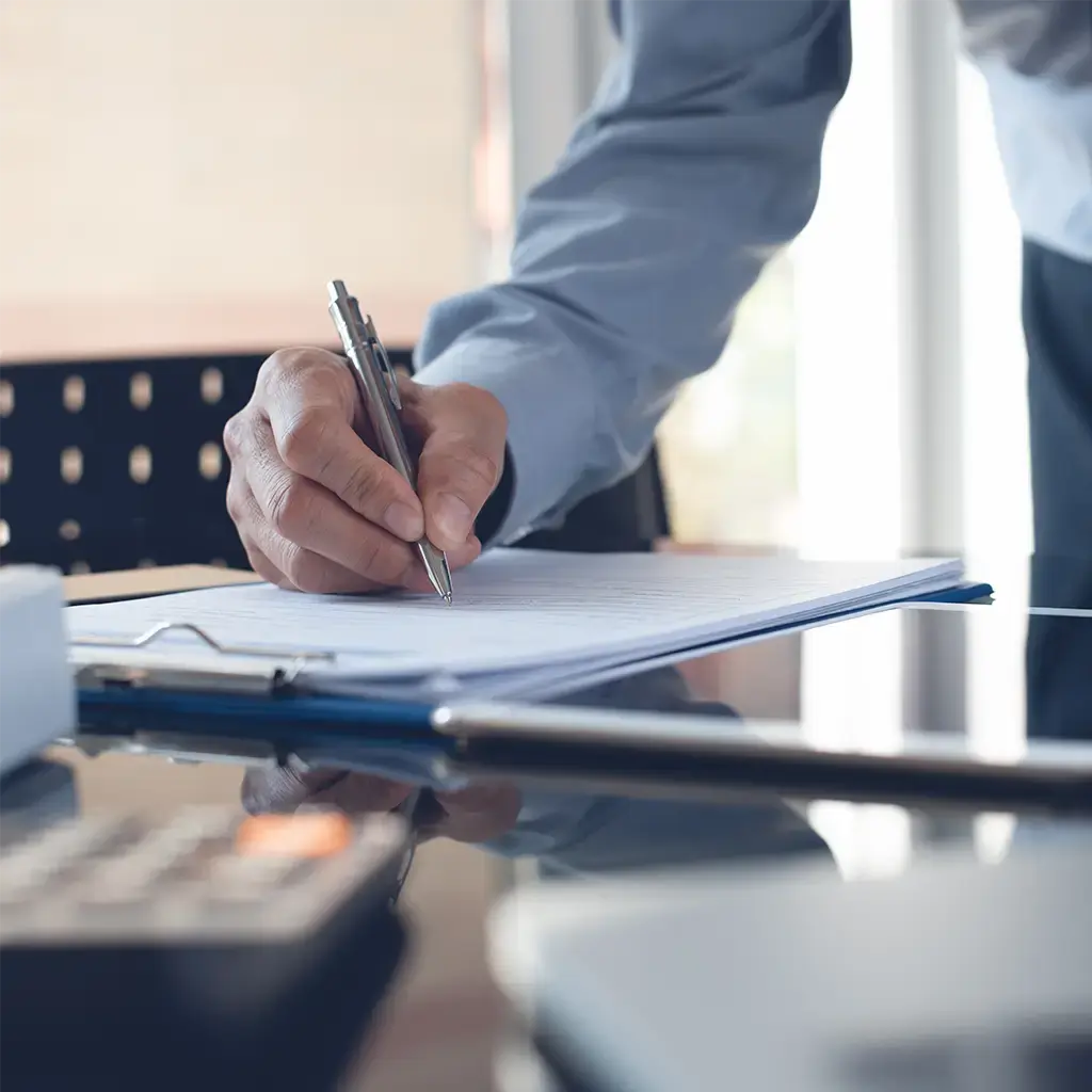 Business professional reviewing documents beside a tablet, symbolizing strategic planning and leadership.
