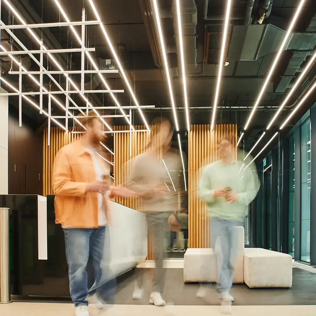 Modern office lobby with three people in motion, representing innovation and global collaboration.