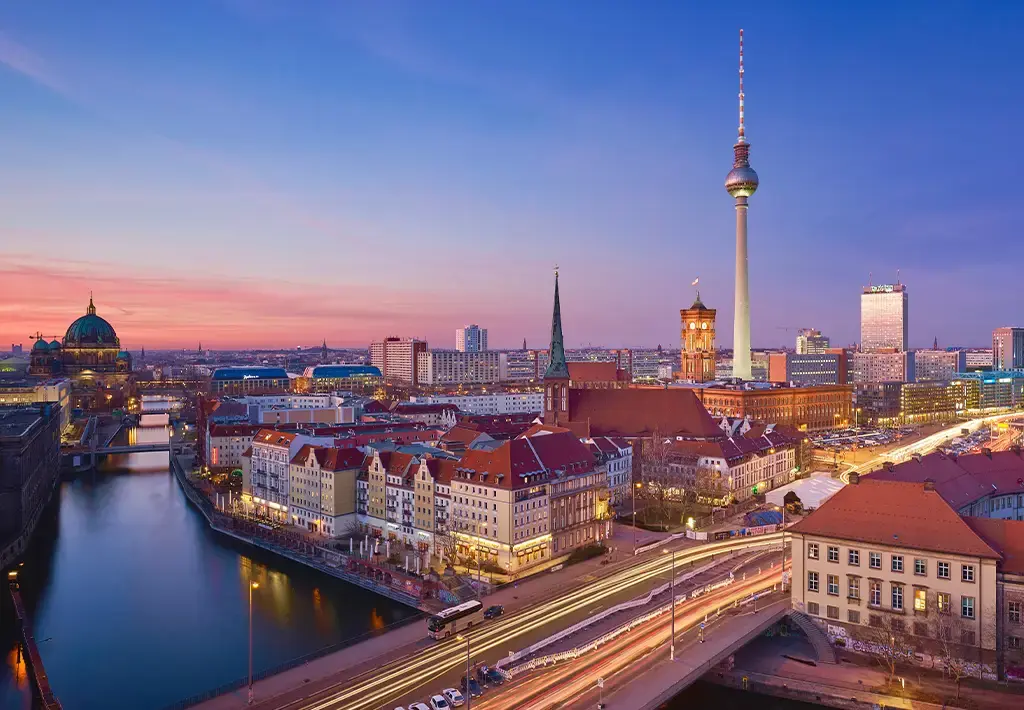 Aerial view of Berlin cityscape at dusk featuring the TV Tower and Spree River.
