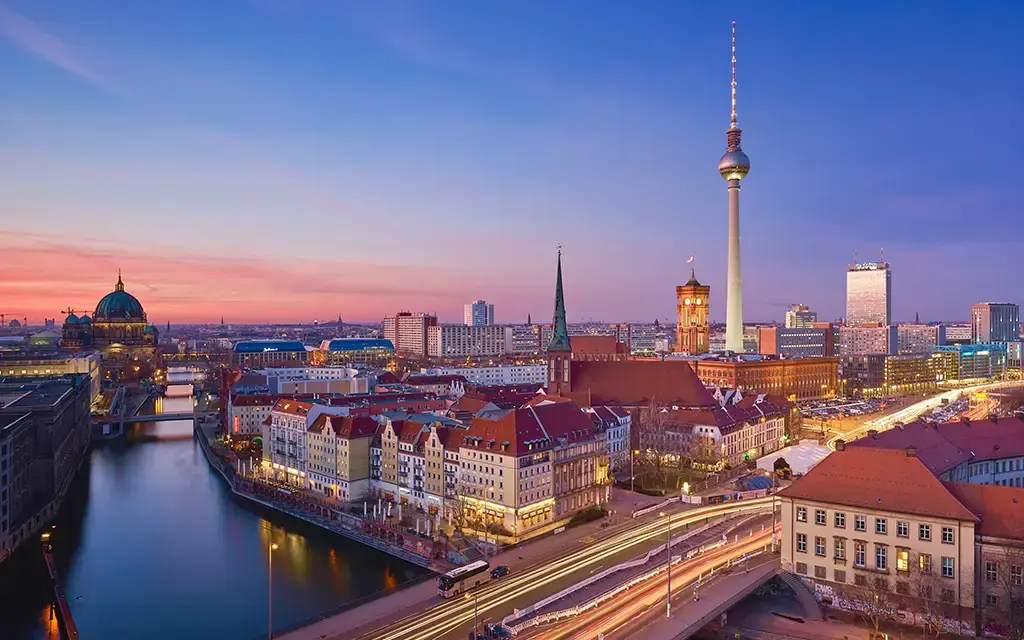 Aerial view of Berlin cityscape at dusk featuring the TV Tower and Spree River.