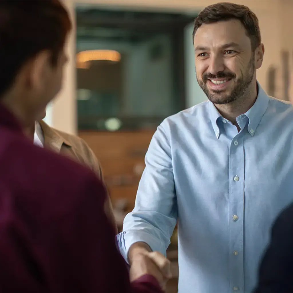 Professional handshake during a business meeting in a modern office setting.