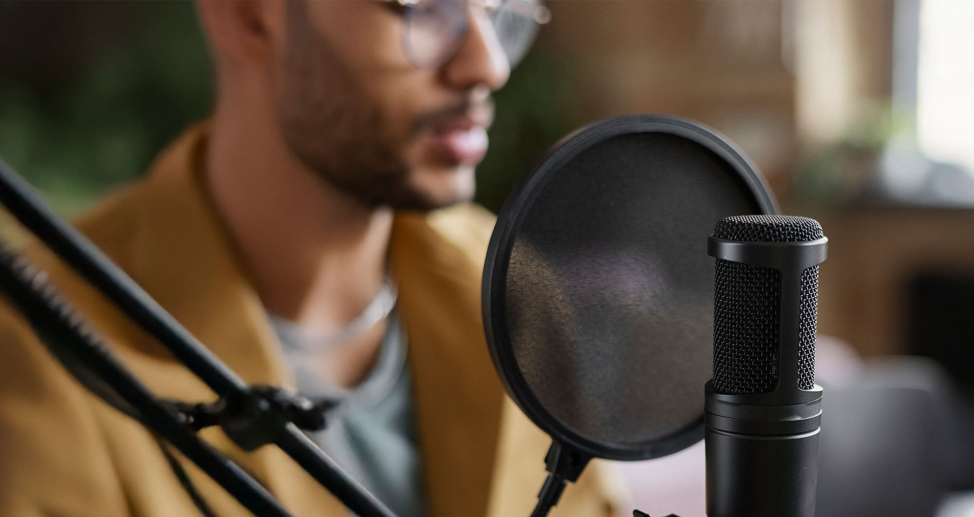 man sitting behind podcast microphone