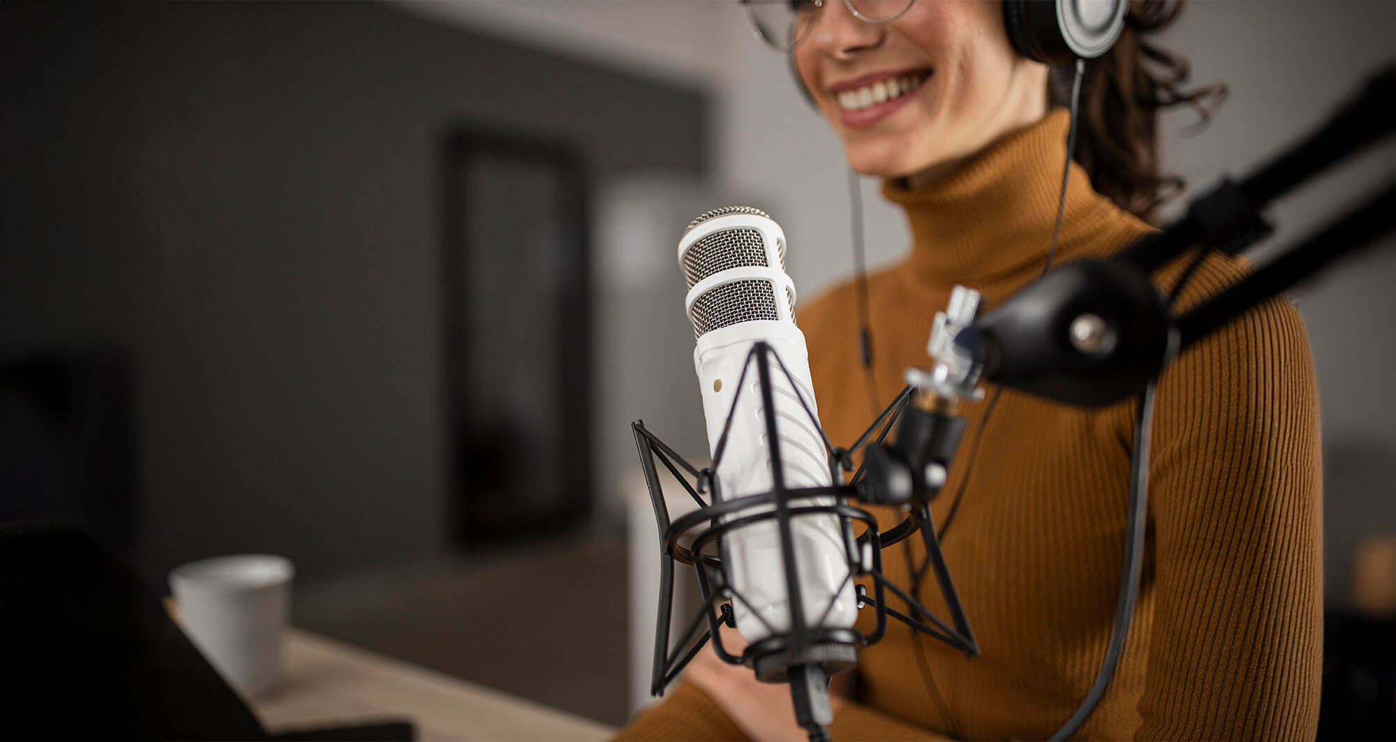 woman smiling with earphones on ready for podcast