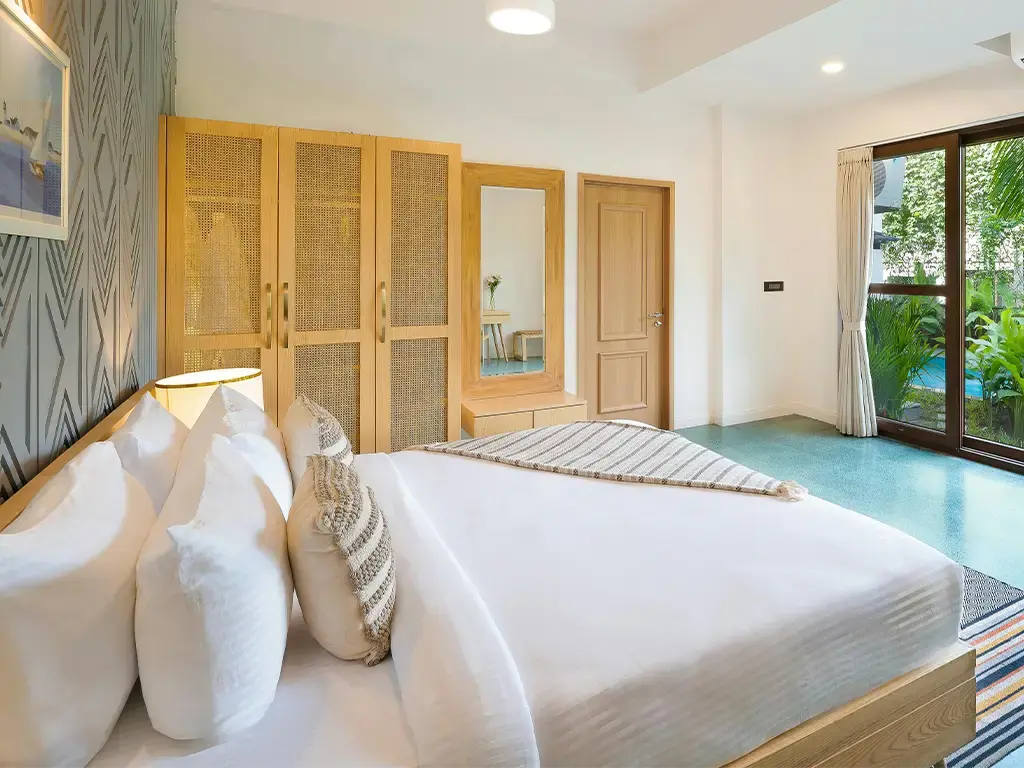 Modern hotel room with large windows, natural light, and minimalistic wooden furnishings.
