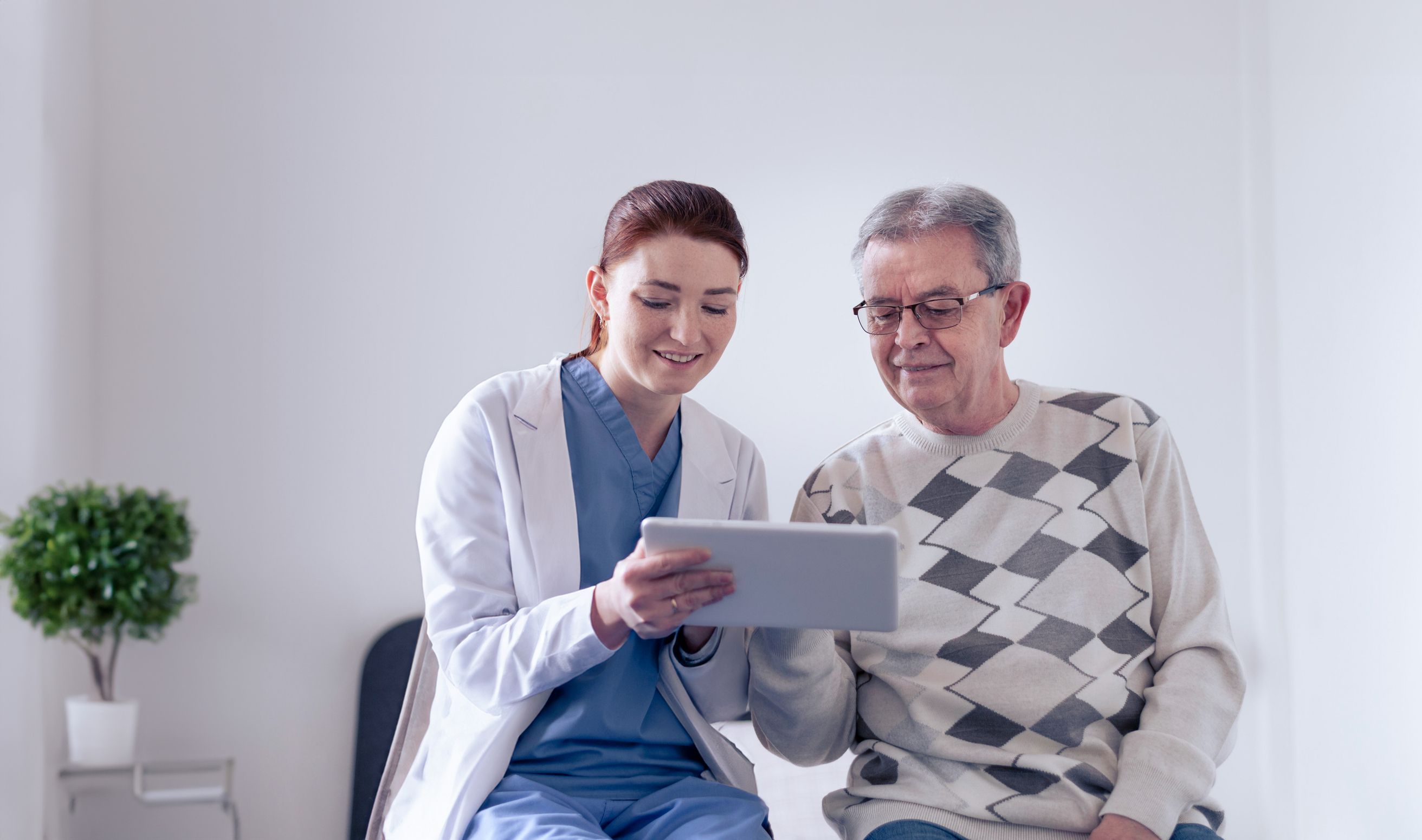 Dcotor showing a patient a something in a tablet