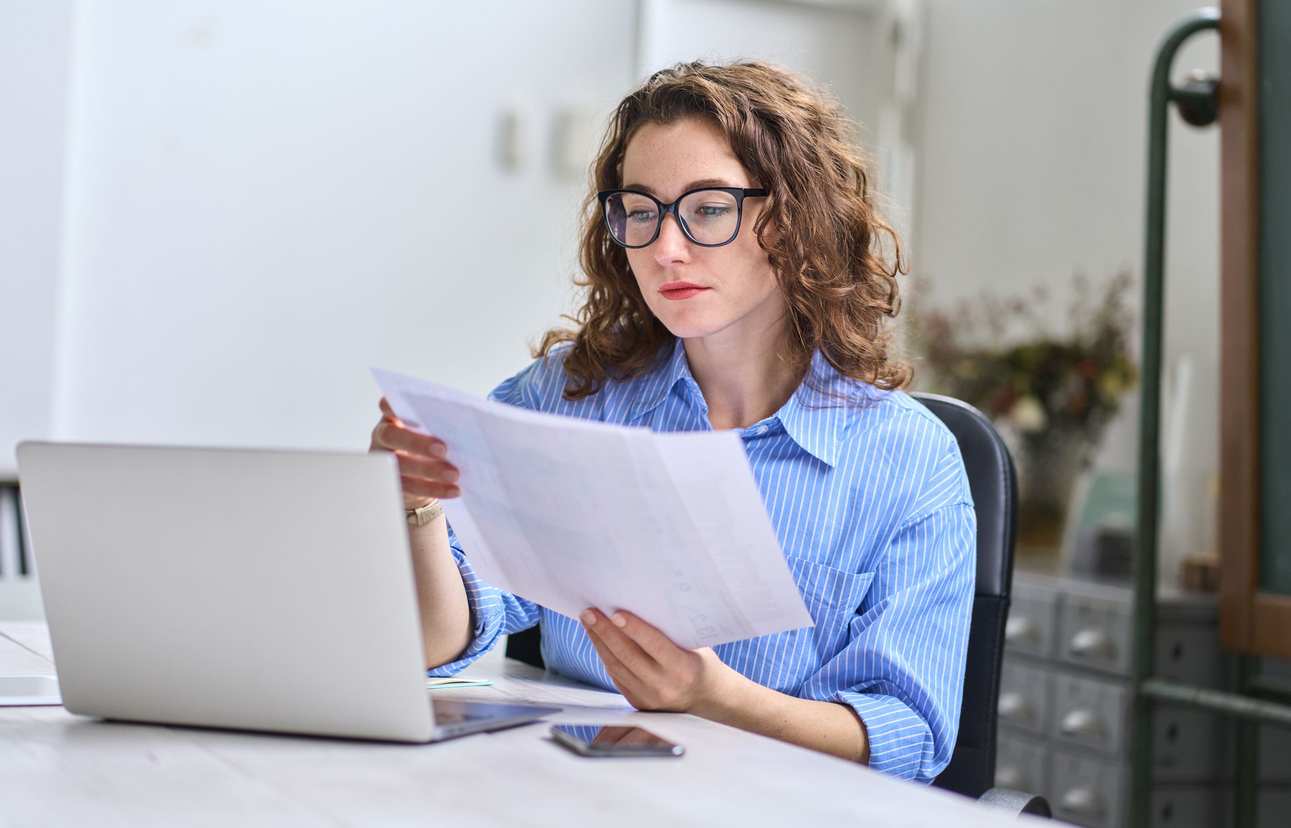 A woman sitting at table making digital insurance payment.