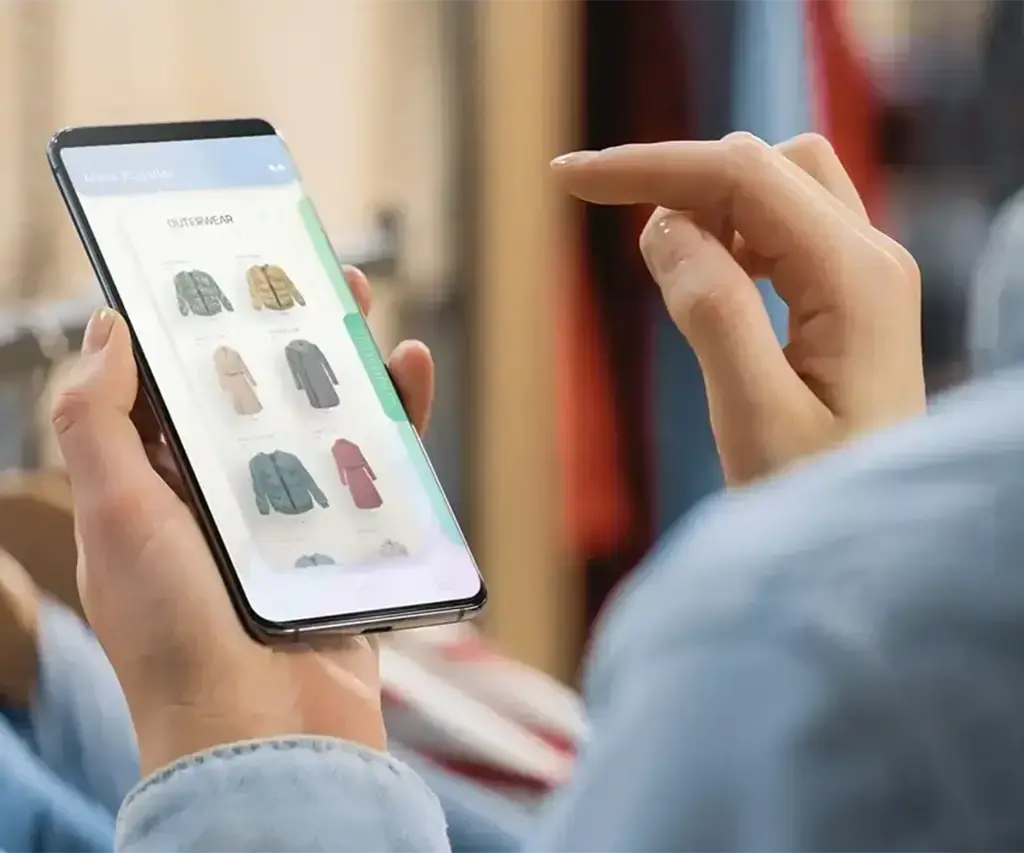person viewing clothing items on mobile app in retail store