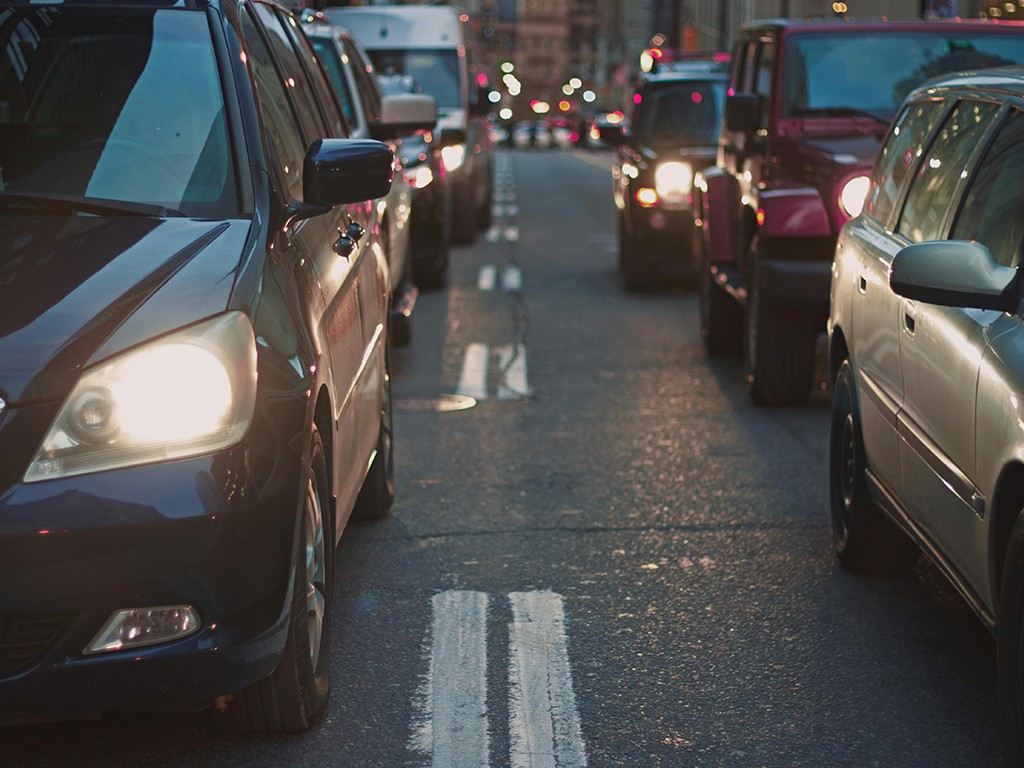 Evening city traffic jam with cars in both lanes, highlighting urban mobility and transport challenges.