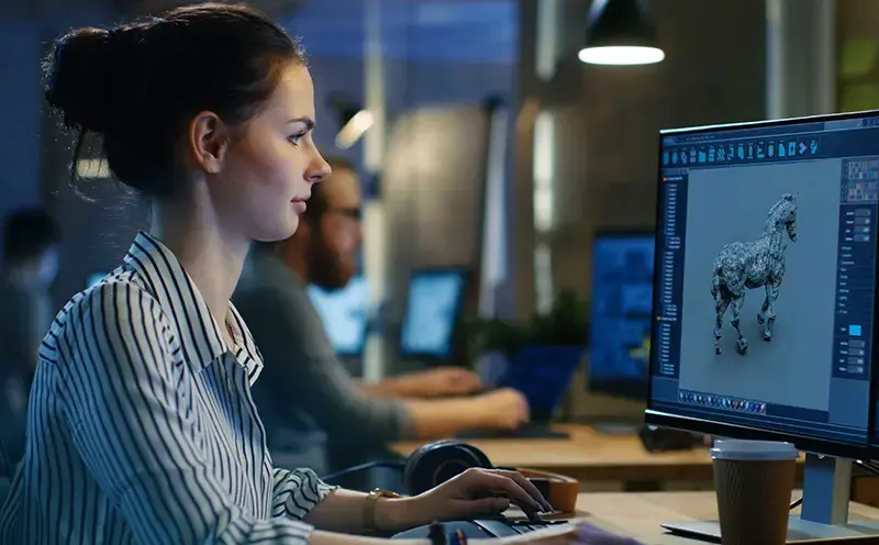 female game artist working on computer model for a game