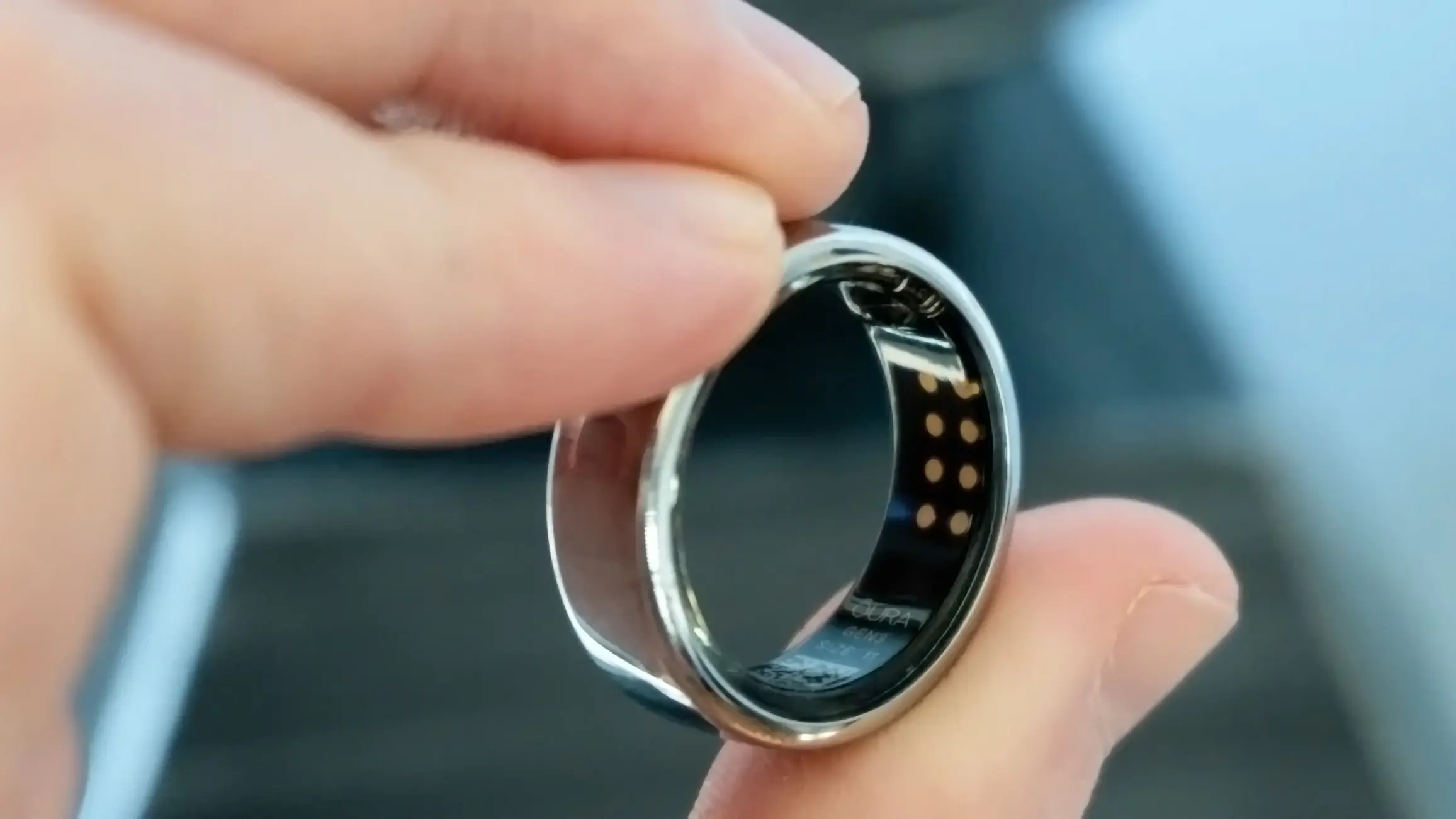 A person holding a black and silver ring, featureing the impact of wearable edge devices on healthcare.
