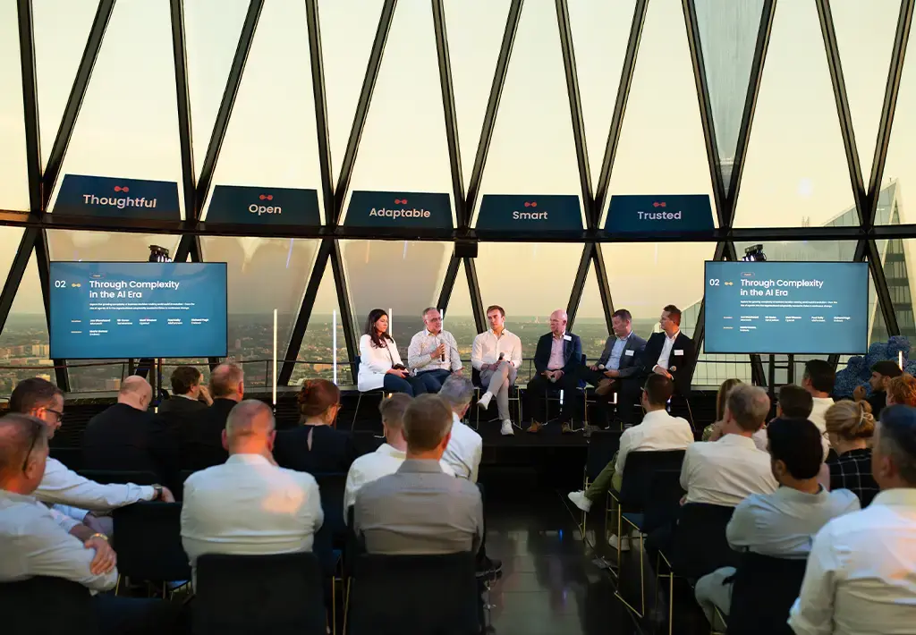 Panel discussion on navigating AI complexity with industry experts at a corporate event in a modern venue.