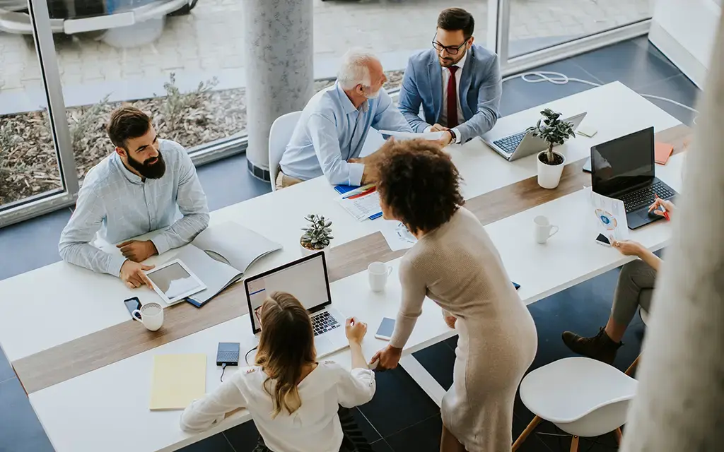 Professionals collaborating in a modern office space, reviewing data and discussing digital strategy.