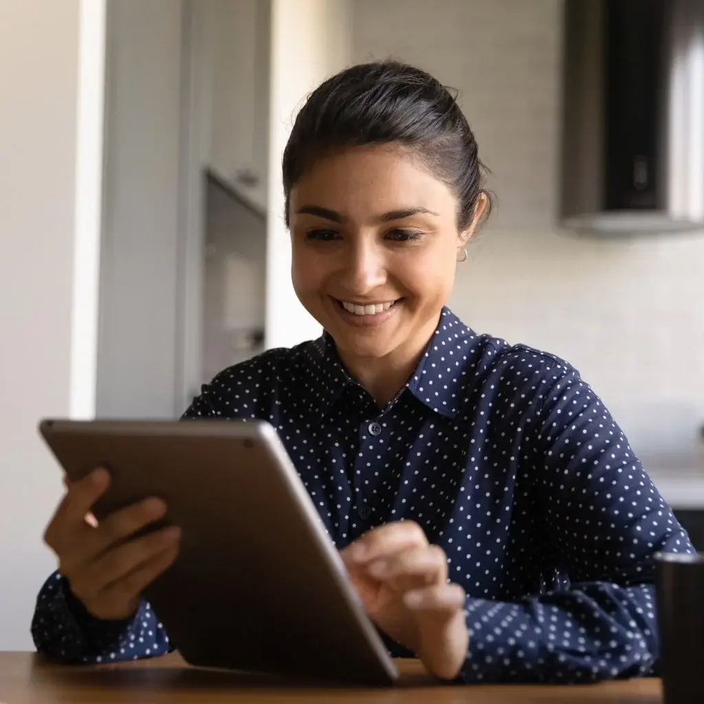 Professional reviewing digital content on a tablet in a modern workspace.