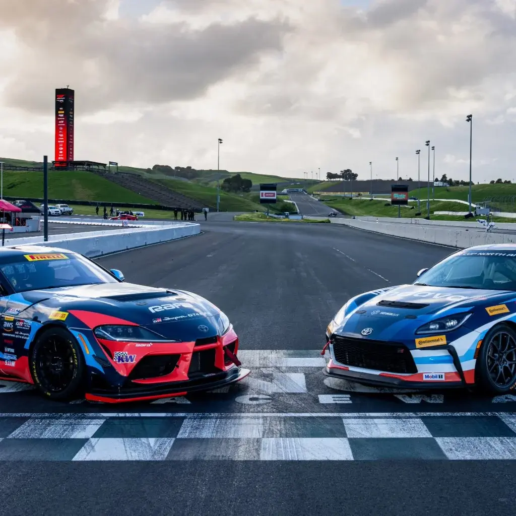 Two Endava-branded race cars positioned on a starting line at a professional racetrack.