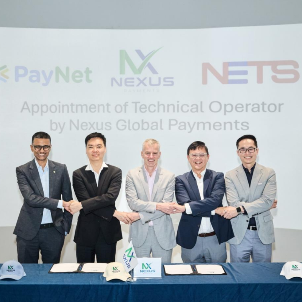 Senior payments executives sign a technical operator agreement, marking a strategic partnership in global payment infrastructure.