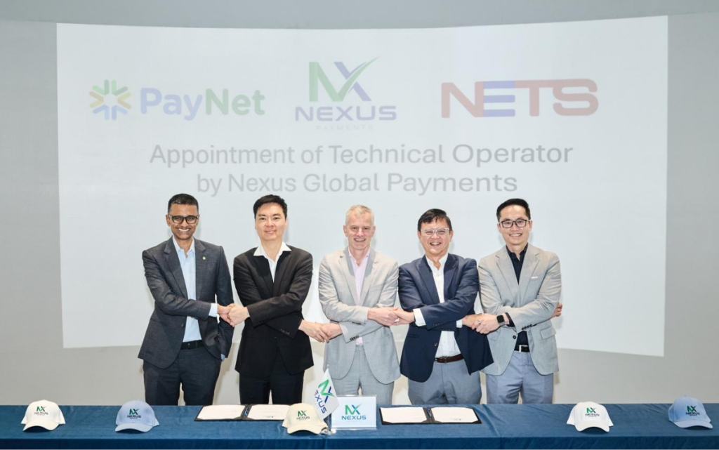 Senior payments executives sign a technical operator agreement, marking a strategic partnership in global payment infrastructure.