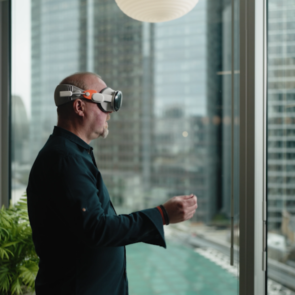Professional using augmented reality headset in modern office overlooking urban cityscape.