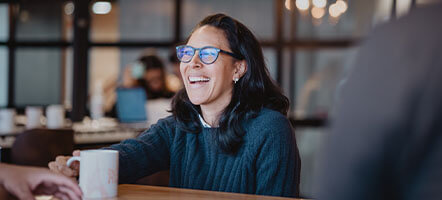 Team member enjoying a coffee in a relaxed office environment, reflecting positive workplace culture.