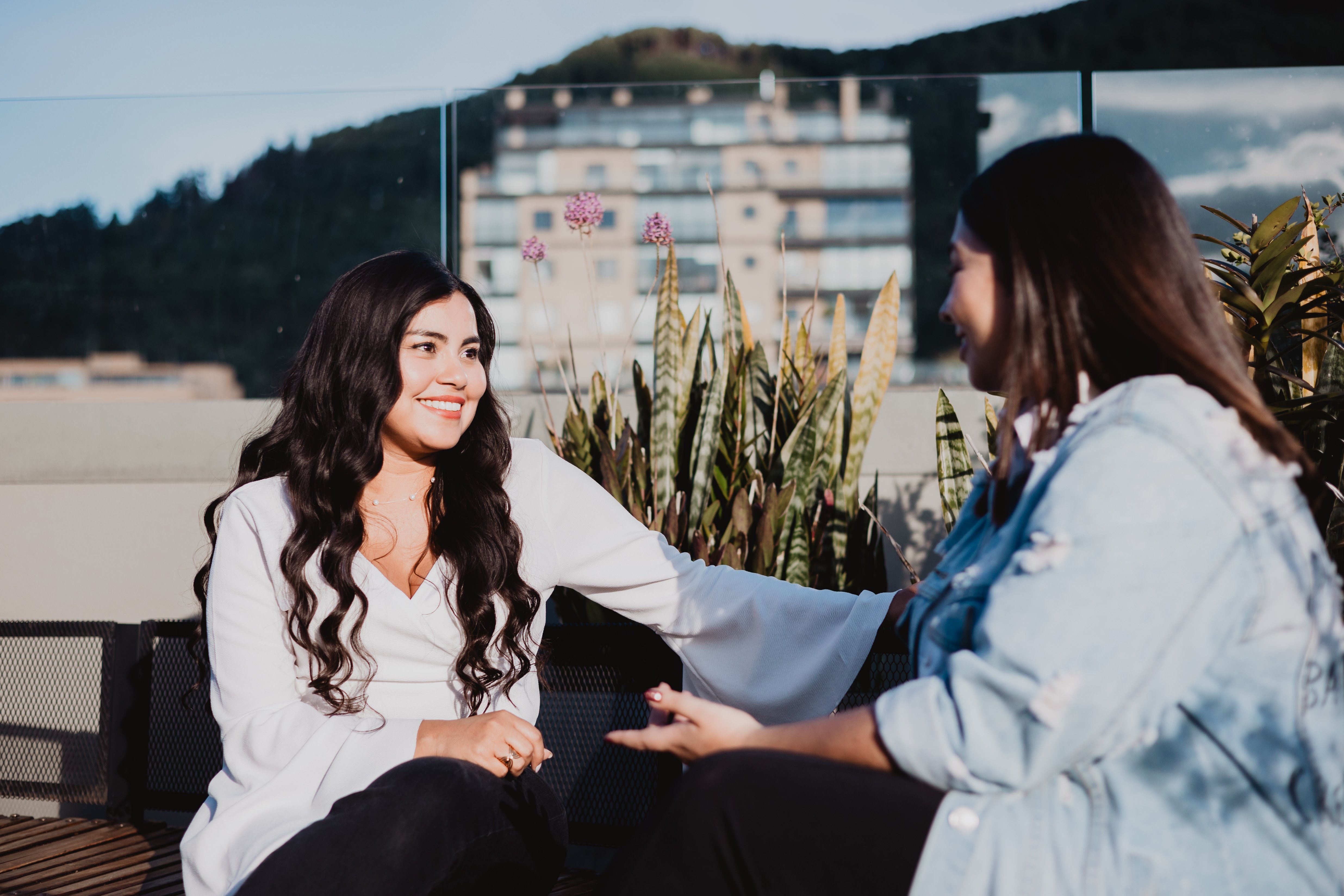 Two women sitting on a bench, having a conversation, focusing on wellbeing