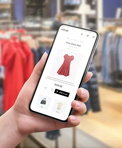 customer holding mobile phone while shopping for red dress