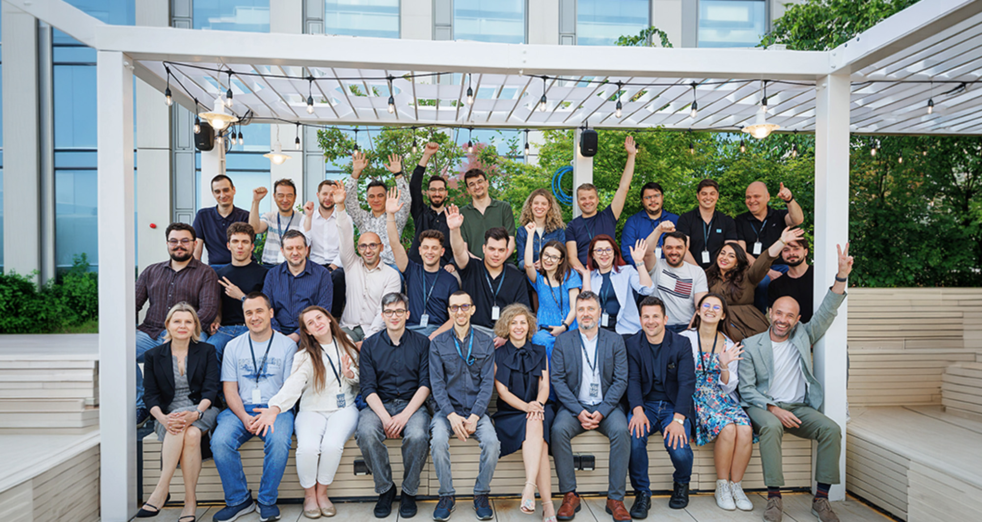 Employees sitting outdoors on benches and smiling